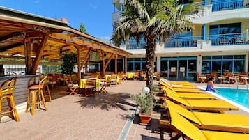 Een buitenzwembad, parasols voor strand/zwembad