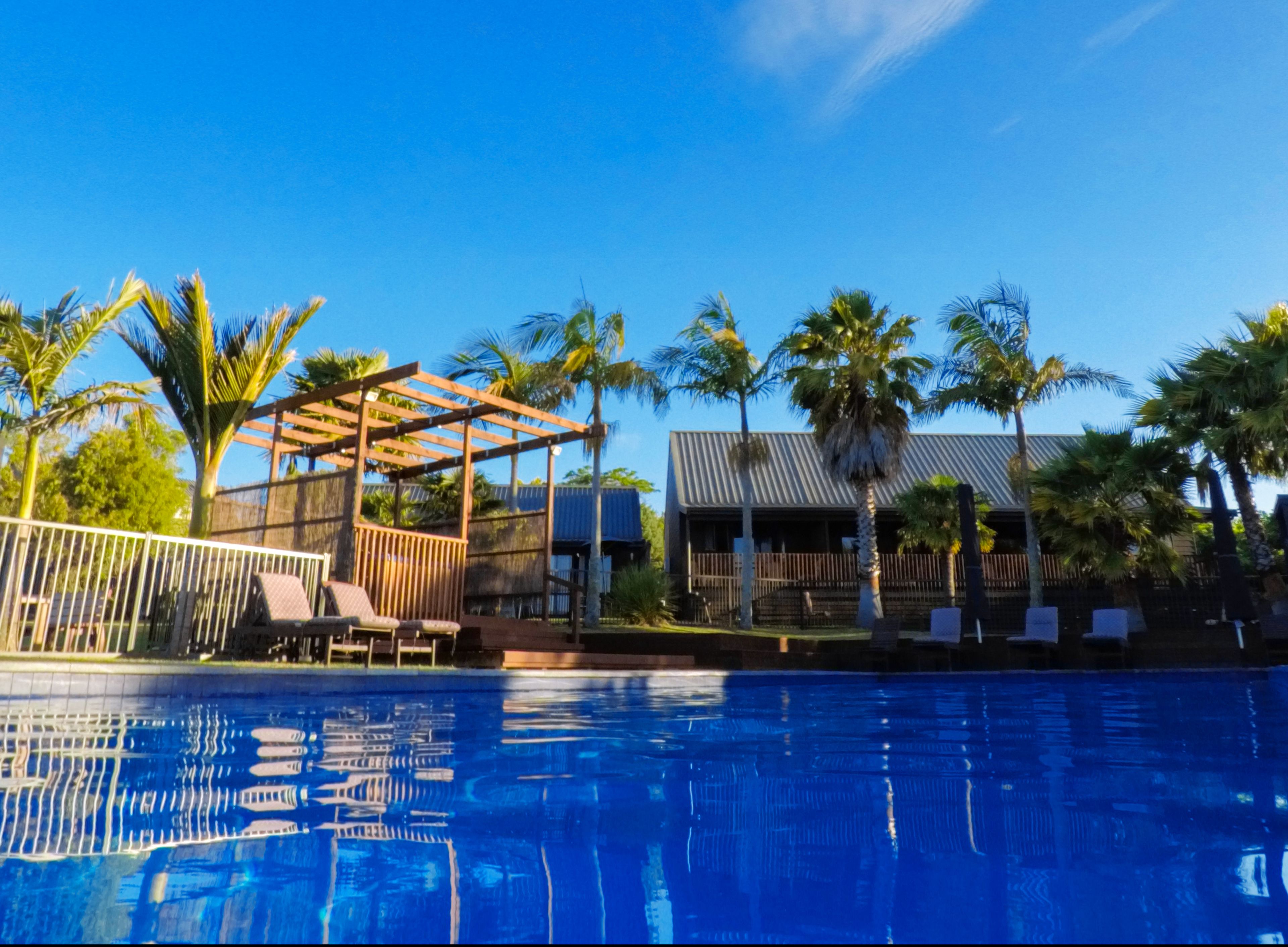 Alberca al aire libre, sombrillas en la alberca y camastros 