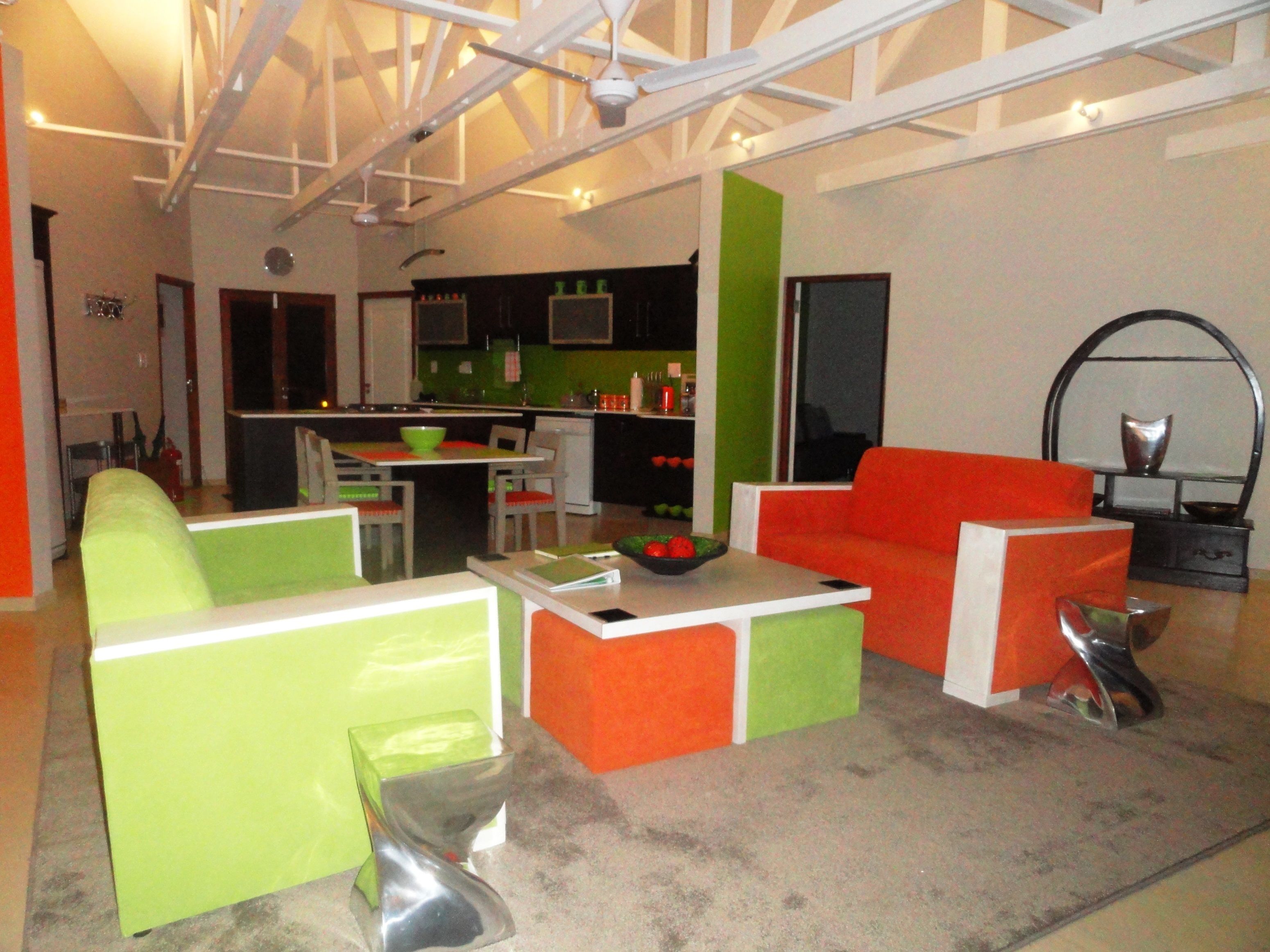 A modern living room with a kitchen in the background.