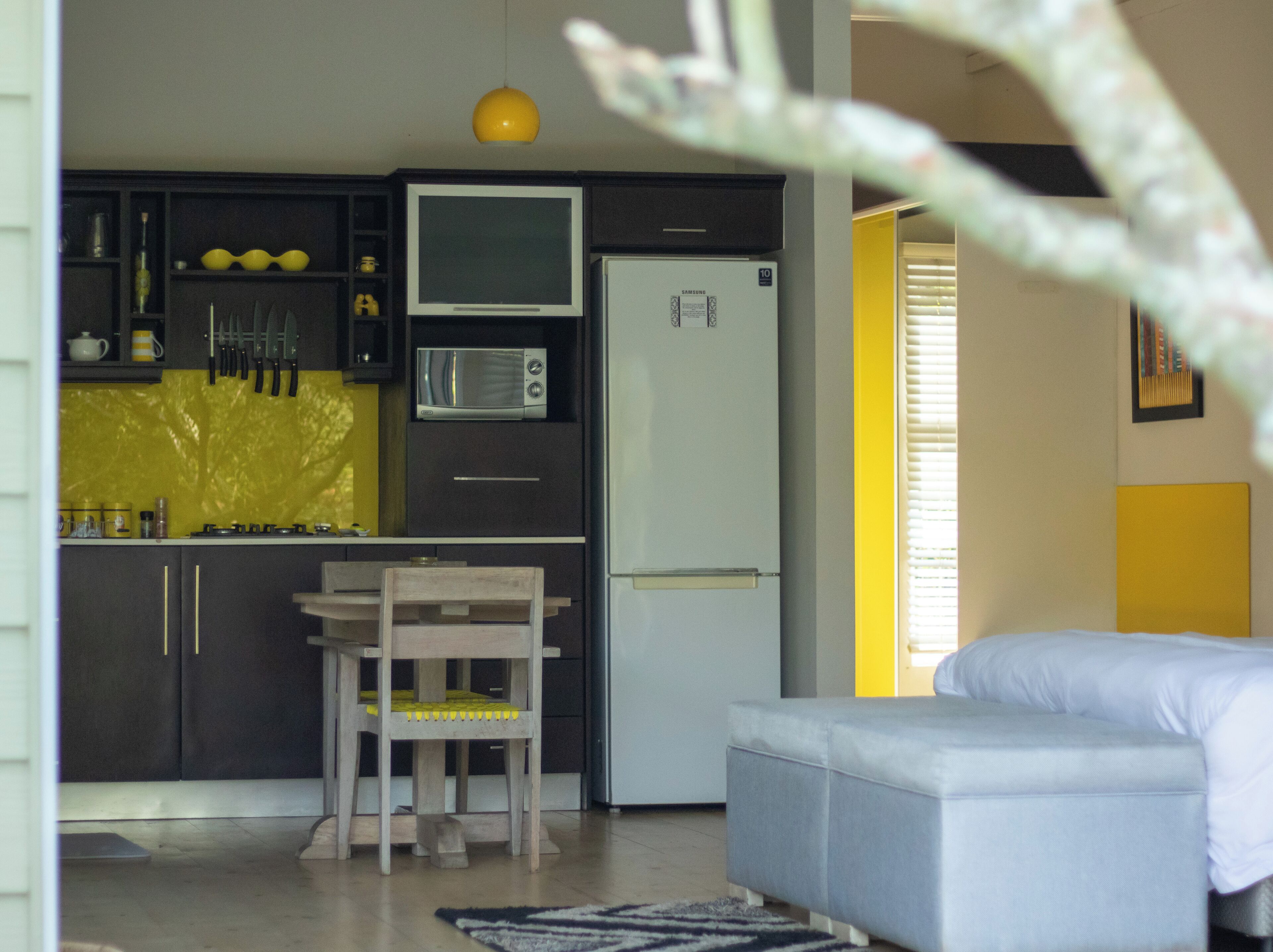 Un espacio habitable compacto con kitchenette, comedor y dormitorio.