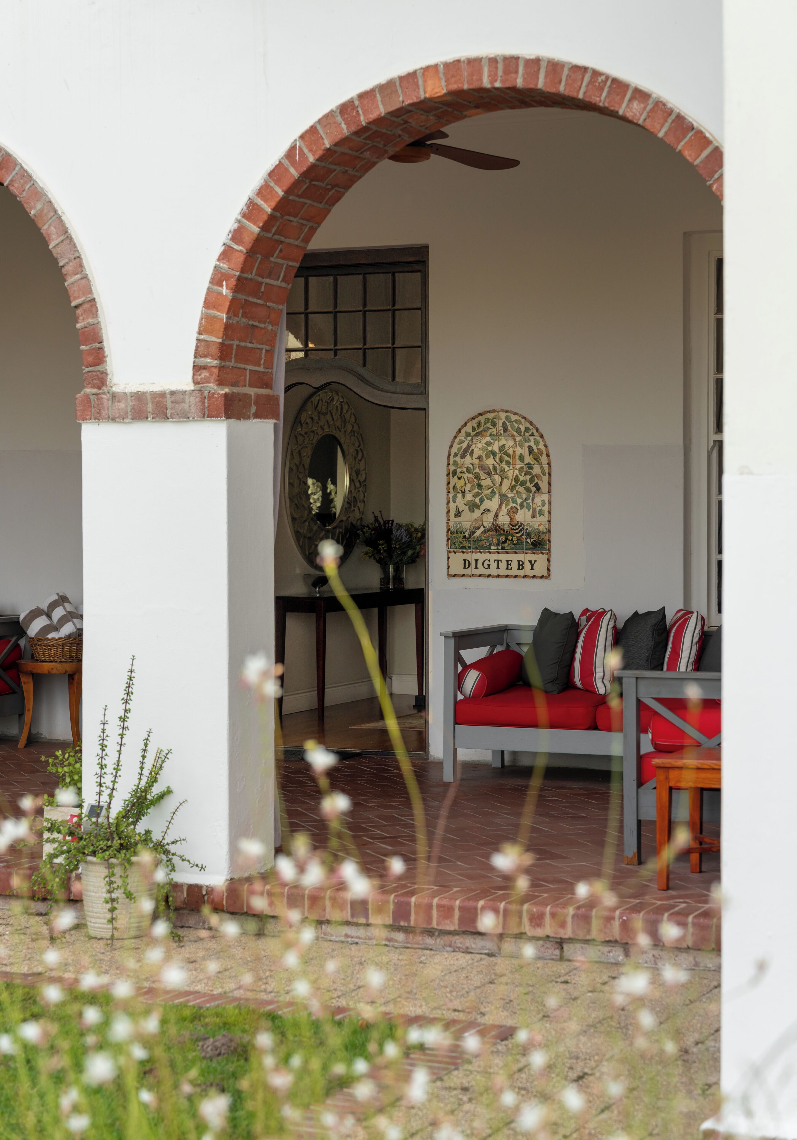 A cozy interior with a red sofa, a decorative wall piece, and a brick archway.