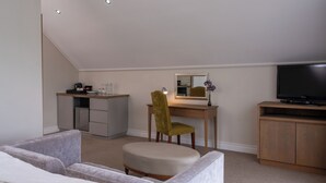 A bedroom with a bed, a desk with a chair, a television, and a small kitchenette. - The Wild Mushroom Luxury Country House (Stellenbosch)