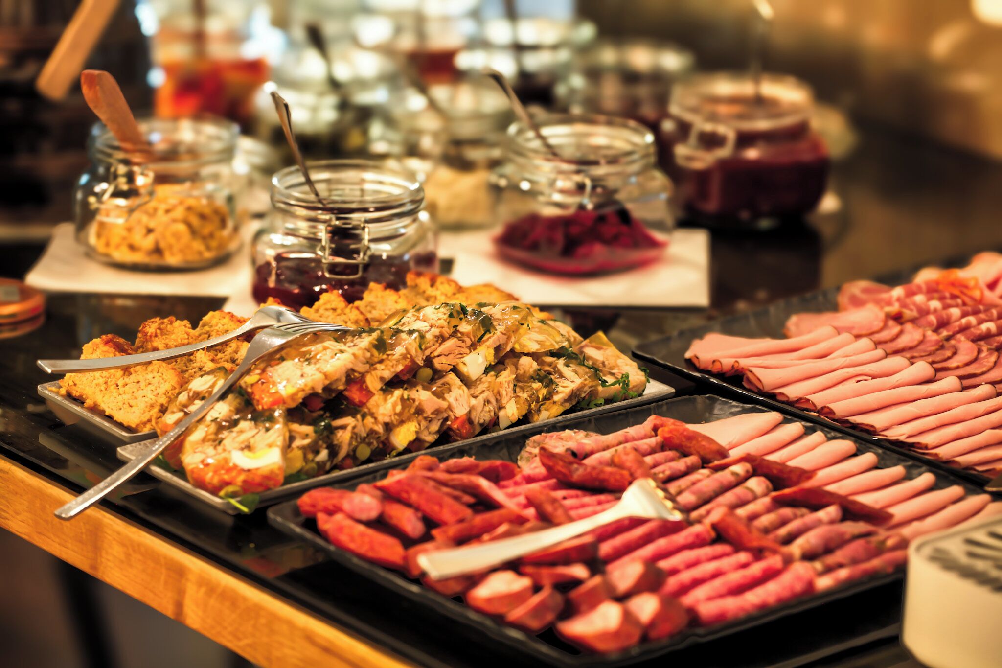 A buffet with various food items including meats, salads, and desserts.