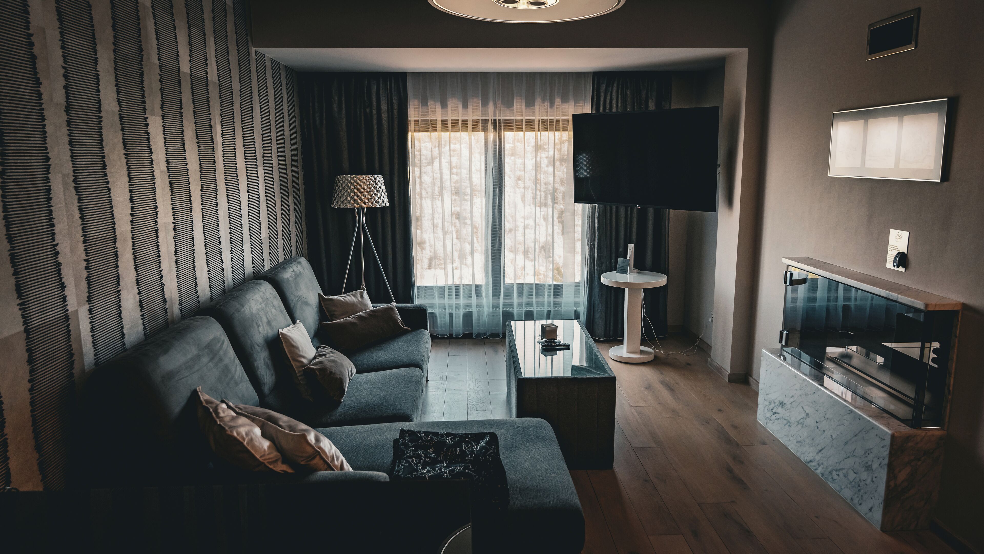 Una sala de estar moderna con un sofá, una mesa de centro, un televisor y una chimenea.