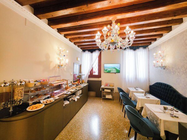 Un restaurant proposant un buffet, avec des poutres apparentes en bois au plafond et un lustre.
