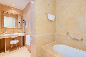 Un bagno con lavandino, specchio, asciugamano e vasca da bagno.
