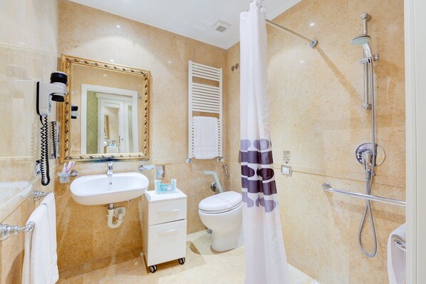Un baño con lavamanos, inodoro y ducha.