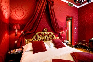 Una camera lussuosa con un letto grande, tende rosse e un design classico.