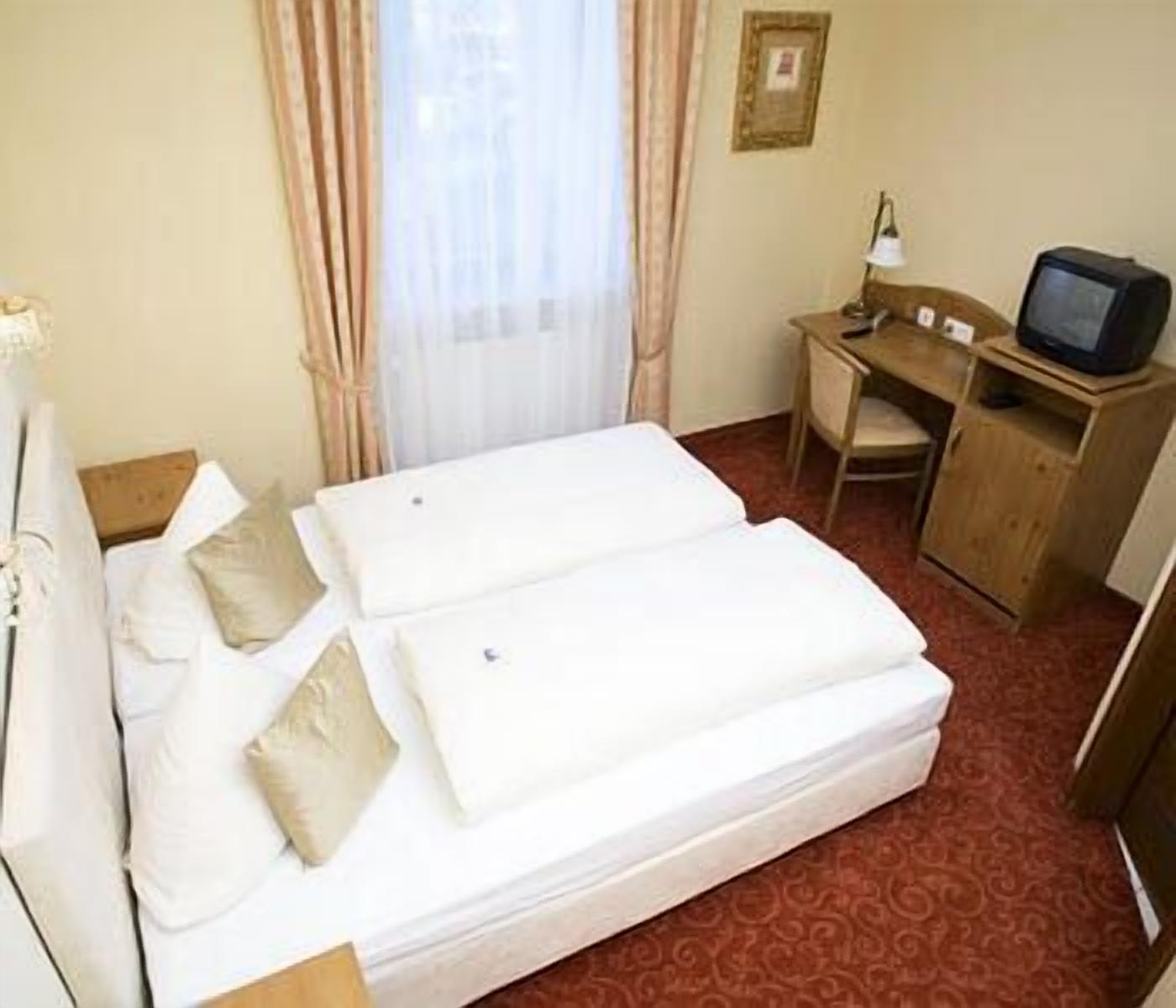 Une chambre d’hôtel avec un lit, un bureau et une télévision.