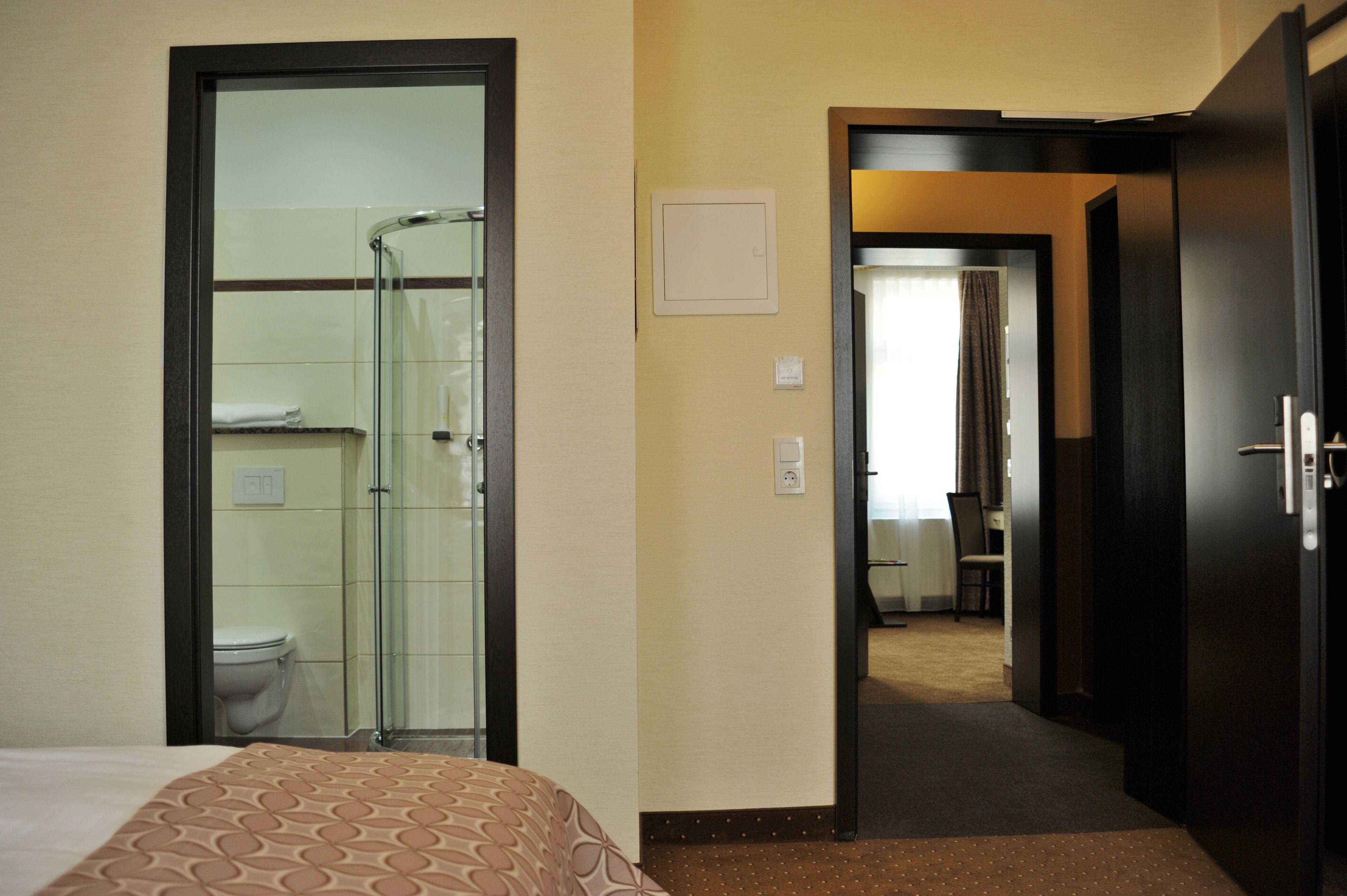 Una habitación de hotel con cama, ducha y baño.