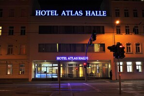 A hotel named "Hotel Atlas Halle" with a prominent illuminated sign, large windows, and a visible entrance. - Hotel Atlas Halle (Halle (Saale))