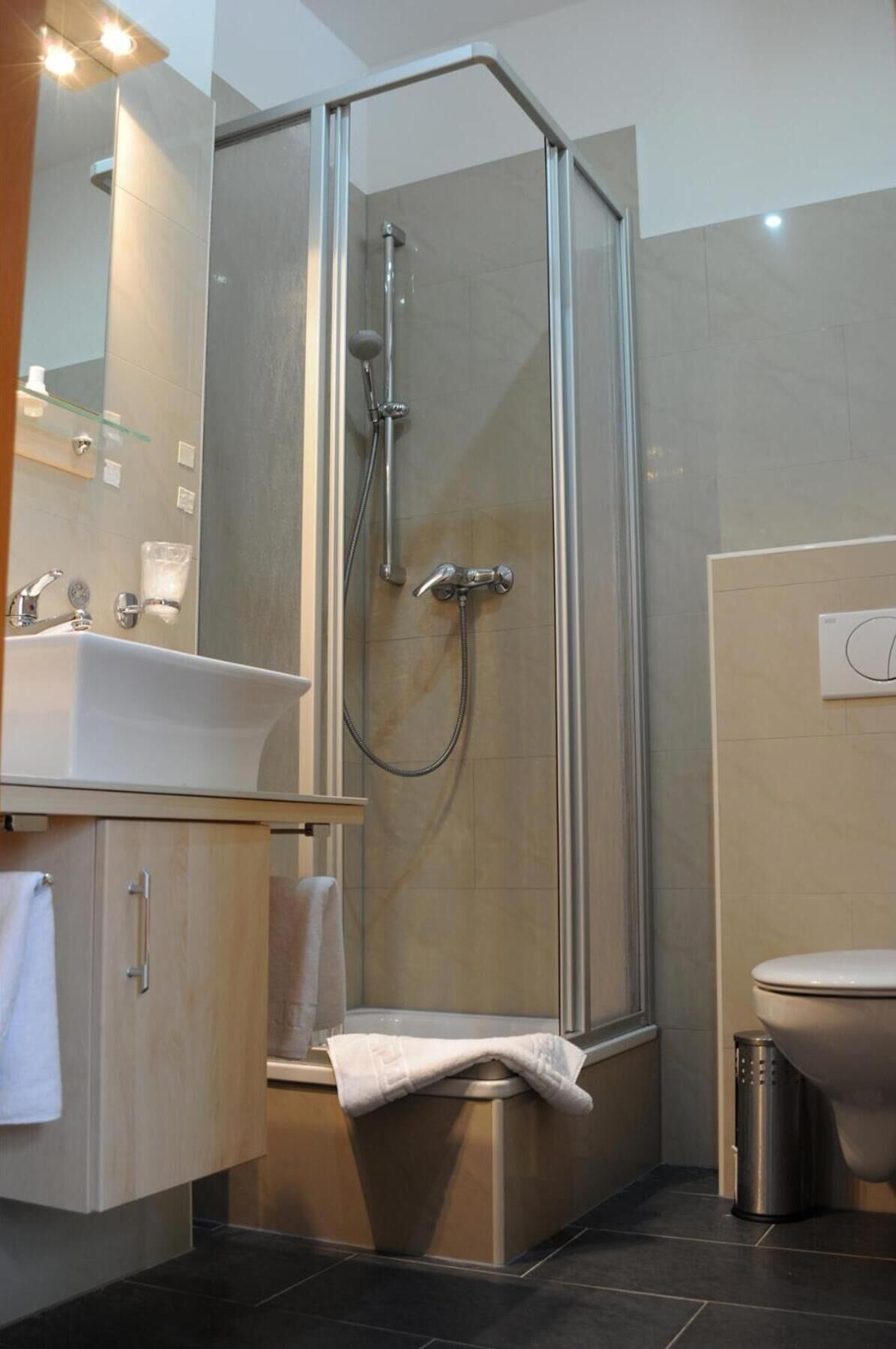 Une salle de bain moderne avec une douche à parois de verre, un lavabo et des toilettes.