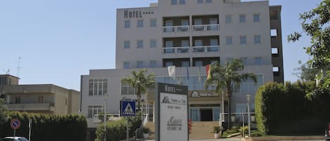 A multi-story hotel with balconies, a pedestrian crossing sign, and a sign for Torre del Sol.