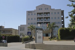 A multi-story hotel with balconies, a pedestrian crossing sign, and a sign for Torre del Sol.