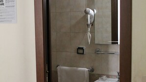 A bathroom with a bidet, sink, and a hairdryer mounted on the wall. - Hotel Pomezia (Rome)