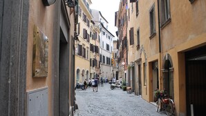 A cobblestone street lined with historic buildings, narrow passageways, and parked bicycles. - Hotel Pomezia (Rome)