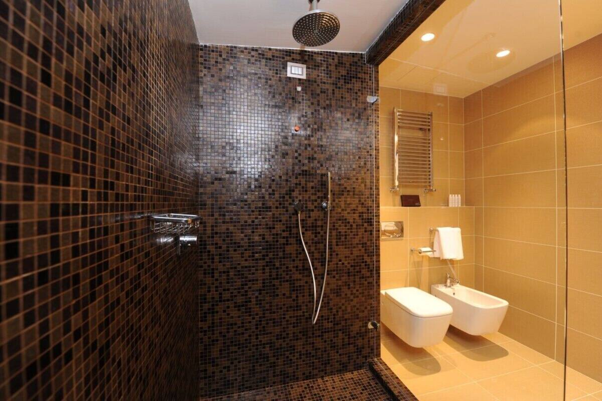 A modern bathroom with a shower, toilet, and bidet.