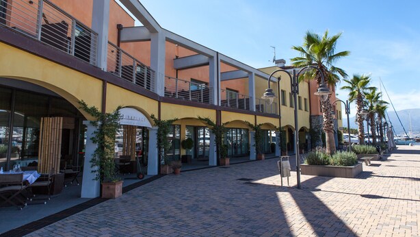 A building with outdoor seating and potted plants. - MarinaPlace Resort & Spa (Genoa)