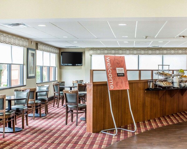 A hotel breakfast area with a buffet, a TV mounted on the wall, and a 'Welcome' sign. - Comfort Suites Wilson I-95 (Wilson)