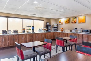 A restaurant with wooden cabinets, a counter with coffee machines, and a seating area with tables and chairs.