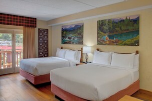 Quarto de hotel com duas camas, varanda e vista, e uma linha do tempo na parede.