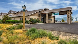 A hotel with a stone facade, a covered entrance, and a sign for Quality Inn. - Quality Inn Selah Yakima (Selah)