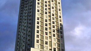 A tall, rectangular hotel building with a flat roof and numerous windows. The name "GOLDEN MILLENIA TOWER" is visible at the base. - Millenia Suites (Pasig)