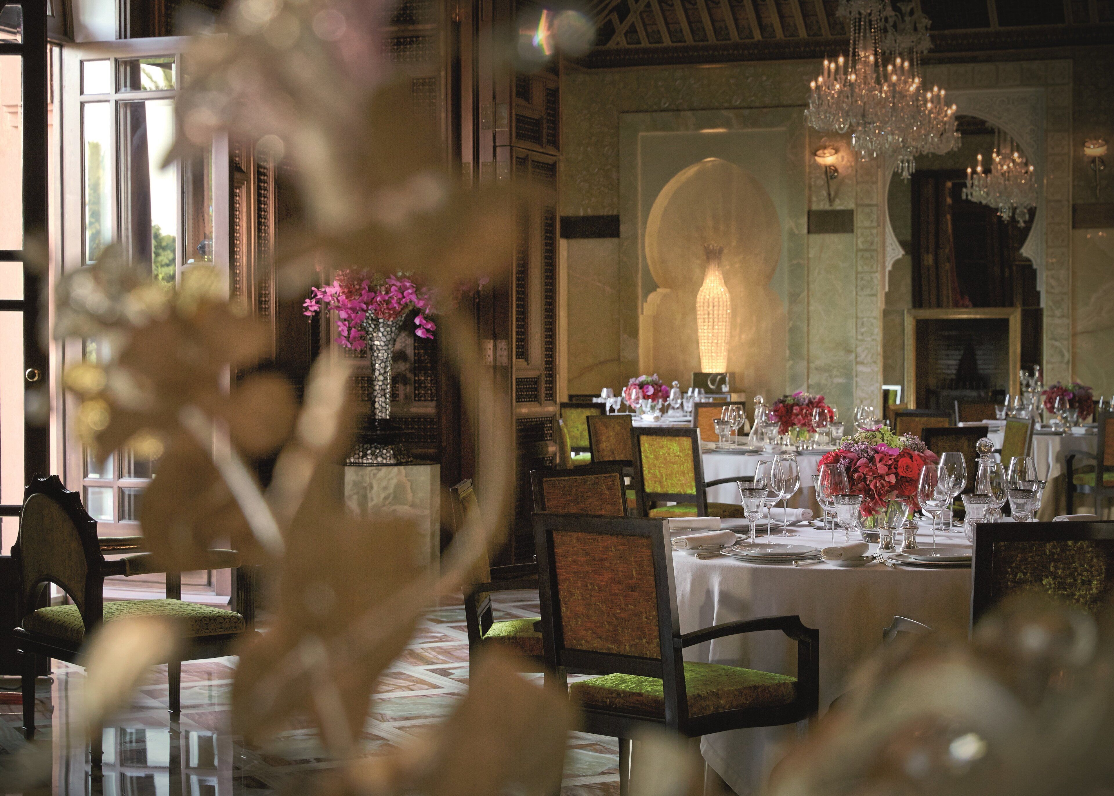 Ein Restaurant mit gedeckten Tischen, mit floralen Mittelstücken und einer eleganten Tischgestaltung.