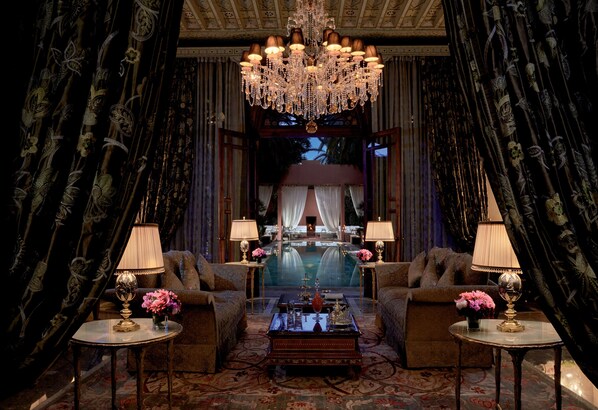 A luxurious lobby with a grand chandelier, plush seating, and a view of a pool. - Royal Mansour Marrakech (Marrakech)