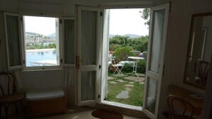 Ein Zimmer mit Blick auf einen Swimmingpool, einen Garten und einer Tür, die zu einer Terrasse führt.