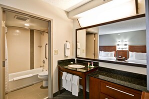A modern bathroom with a bathtub, toilet, sink, and a large mirror. - Hyatt Place San Antonio–North/Stone Oak (San Antonio)