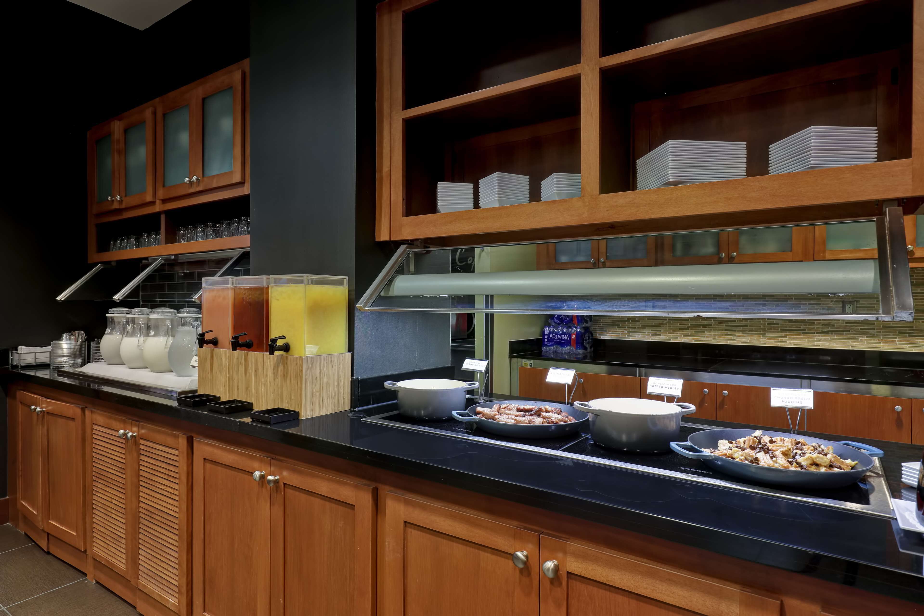 A buffet setup with various food items and glassware.
