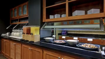 A buffet setup with various food items and glassware.