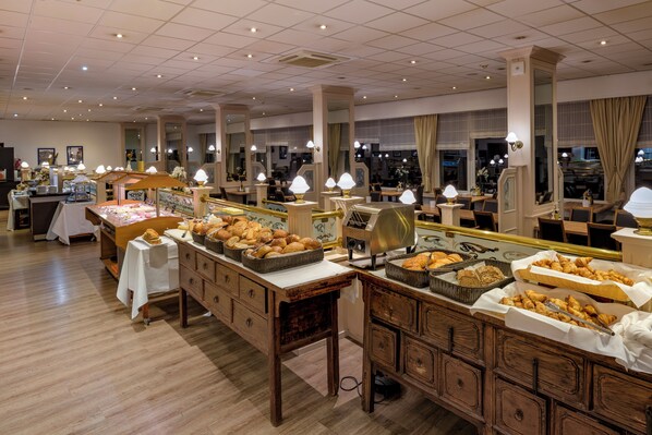A buffet area with various food items and tables. - Hotel des Nordens by Sunday Hotels (Harrislee)