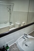 A bathroom with a bathtub, toilet, and sink.