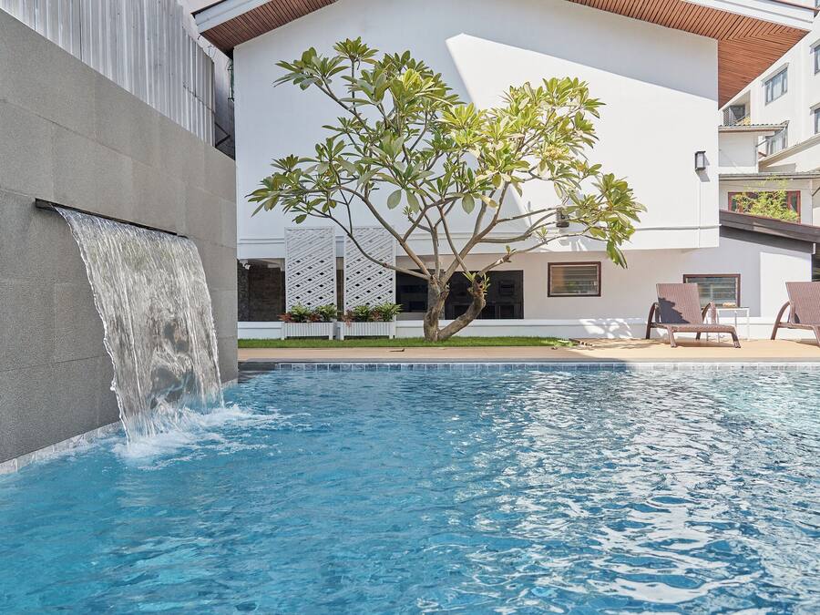 Una piscina al aire libre, sombrillas, tumbonas