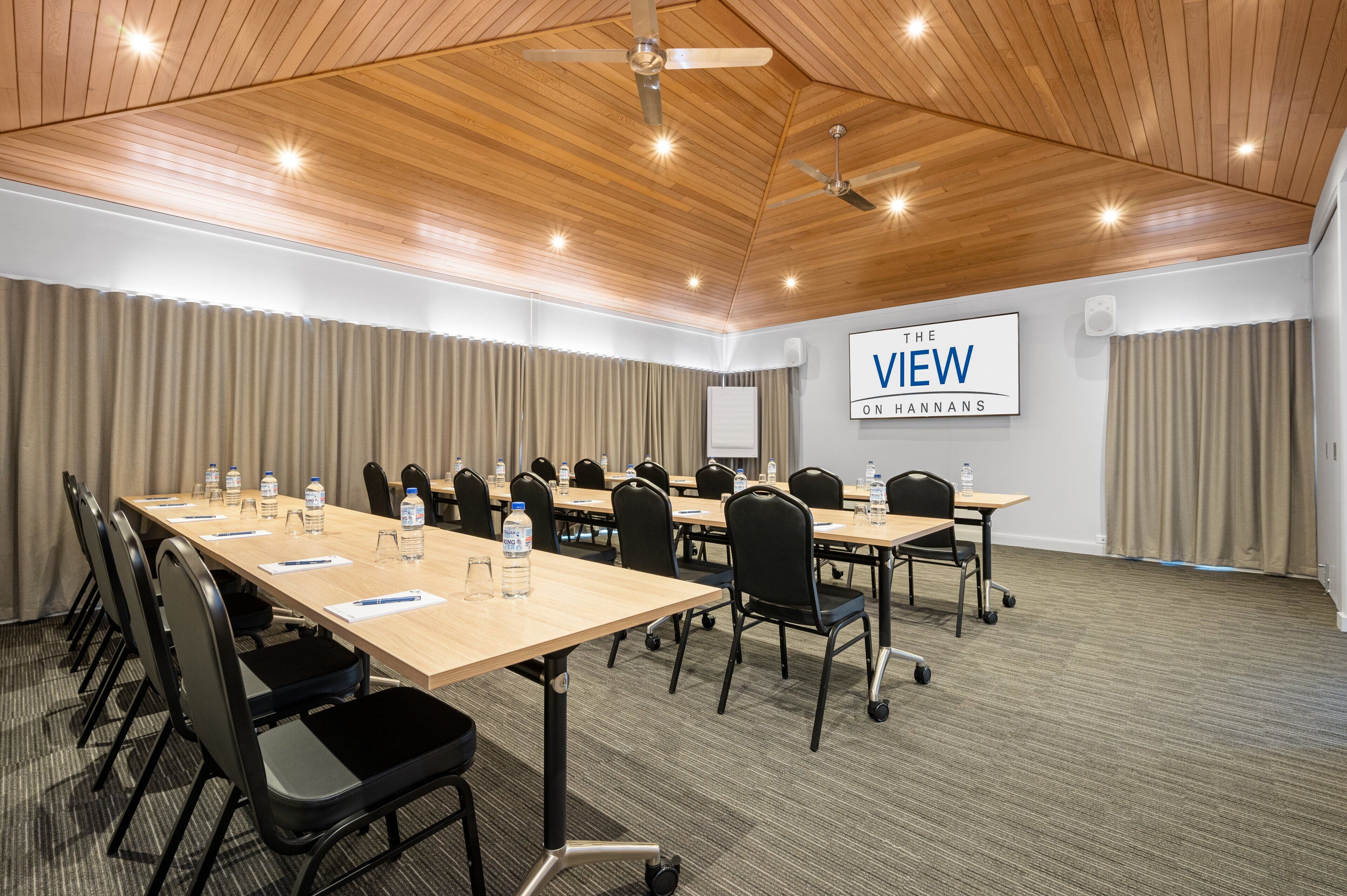 A conference room with a long table, chairs, and a sign reading "VIEW ON HANNANS".