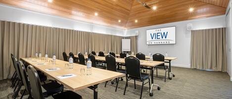 A conference room with a long table, chairs, and a sign reading "VIEW ON HANNANS".