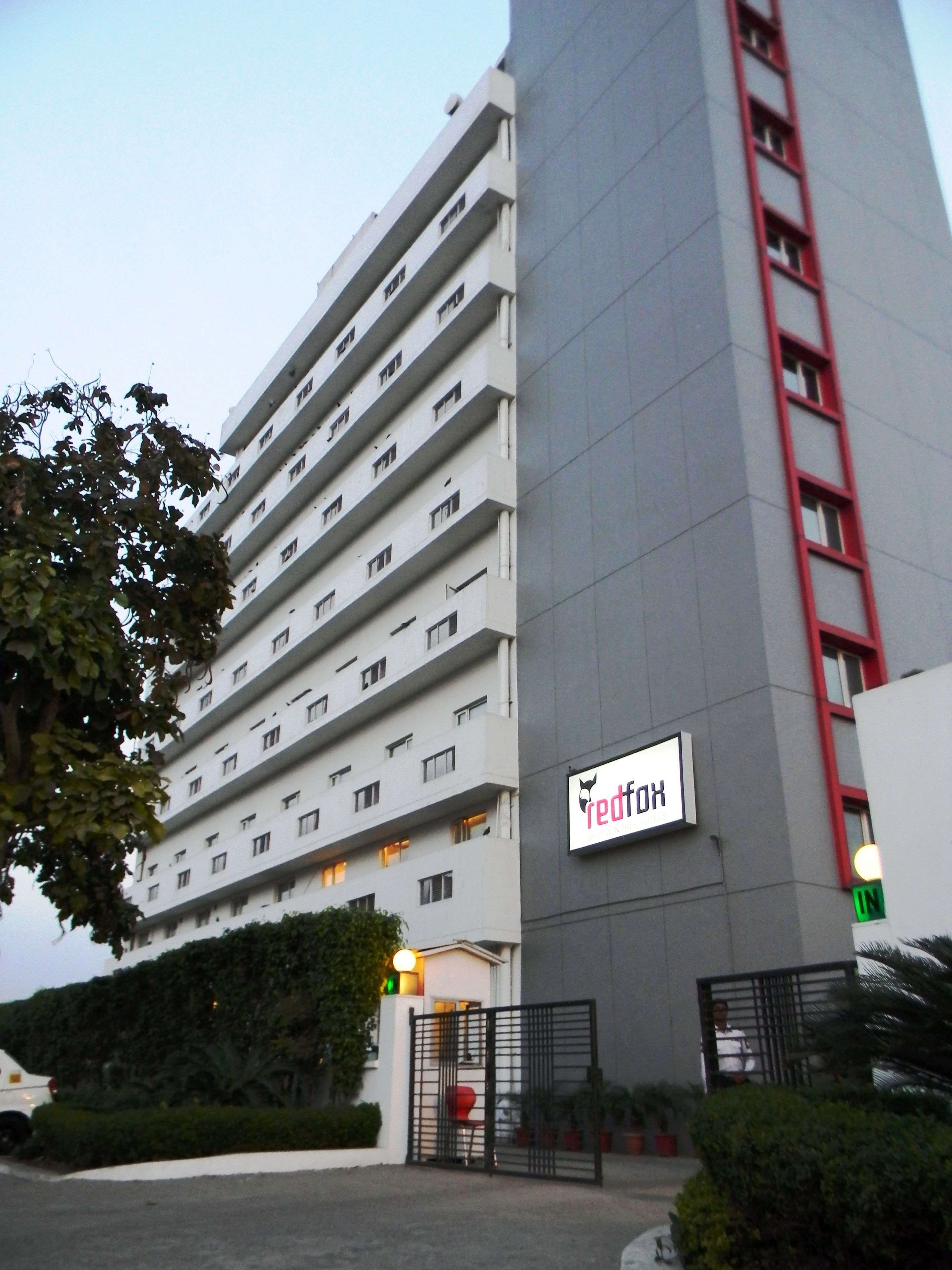 Un hotel de varios pisos con un letrero rojo y blanco llamativo.