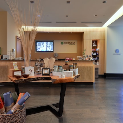 A reception area with a wooden reception desk, a television screen, and a wall-mounted clock.