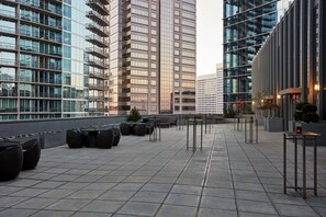 A rooftop terrace with outdoor seating and a view of surrounding high-rise buildings. - Loews Atlanta Hotel (Atlanta)