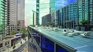 A rooftop terrace with outdoor seating and a view of surrounding high-rise buildings. - Loews Atlanta Hotel (Atlanta)