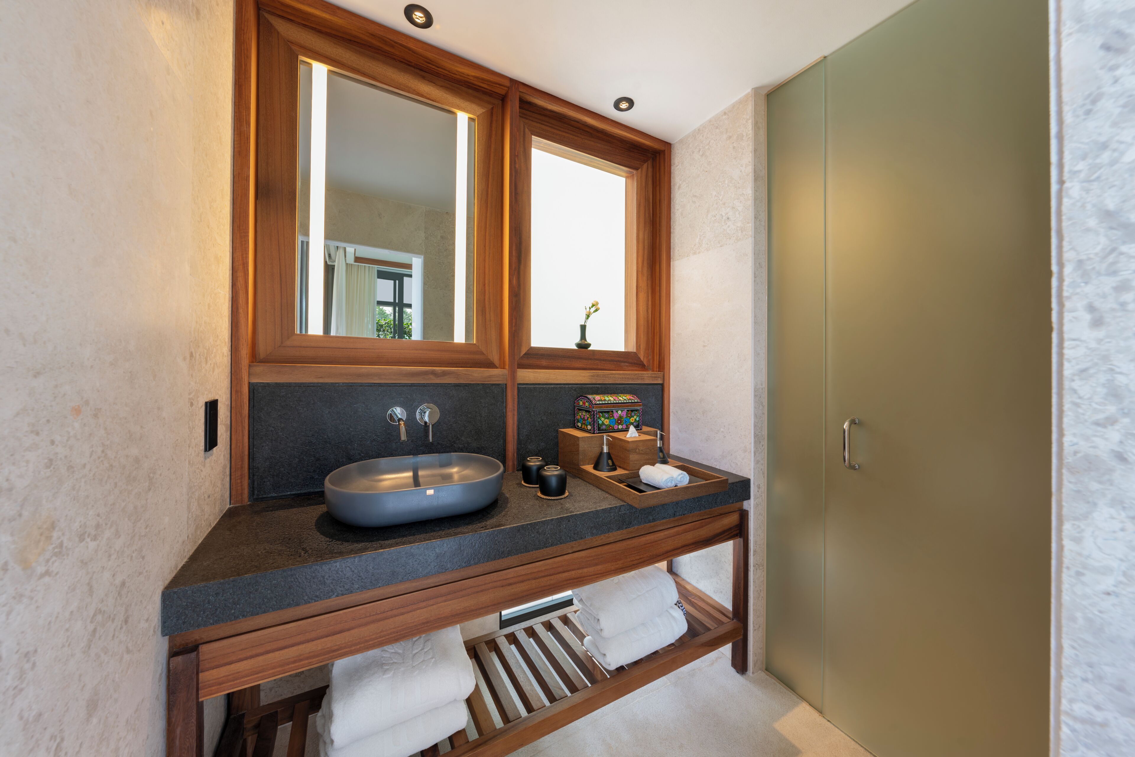 A bathroom with a large mirror, a sink, and a towel rack.