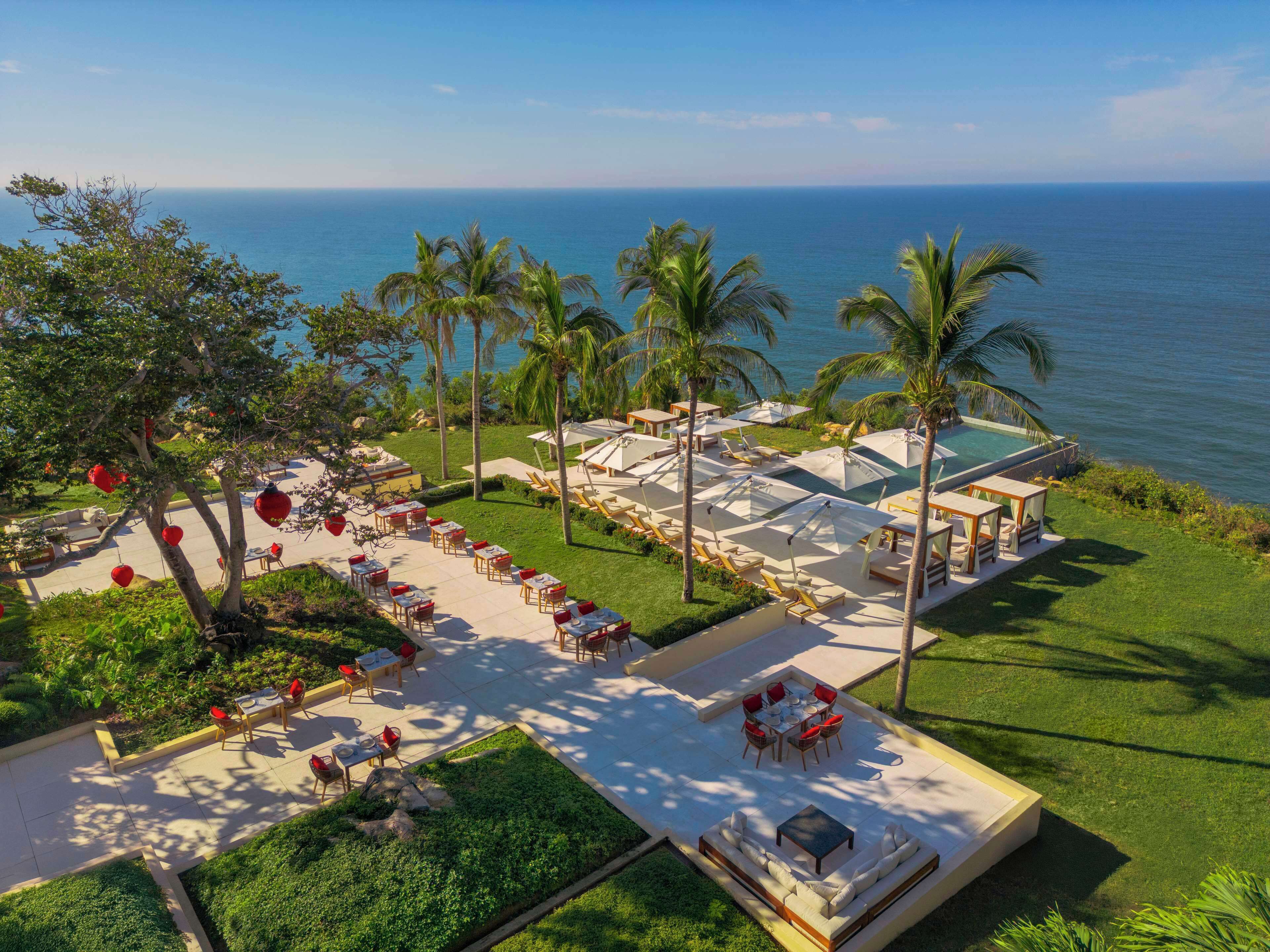 Ein Resort mit Sitzgelegenheiten im Freien, einem Pool und Blick auf das Meer.