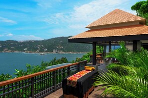 A wooden deck with a massage table, a small gazebo, and a view of the sea and hills. - Banyan Tree Cabo Marques (Acapulco)