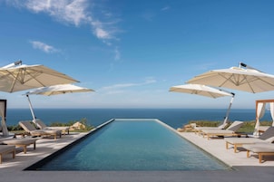 Una piscina al aire libre, camas de piscina gratis, sombrillas