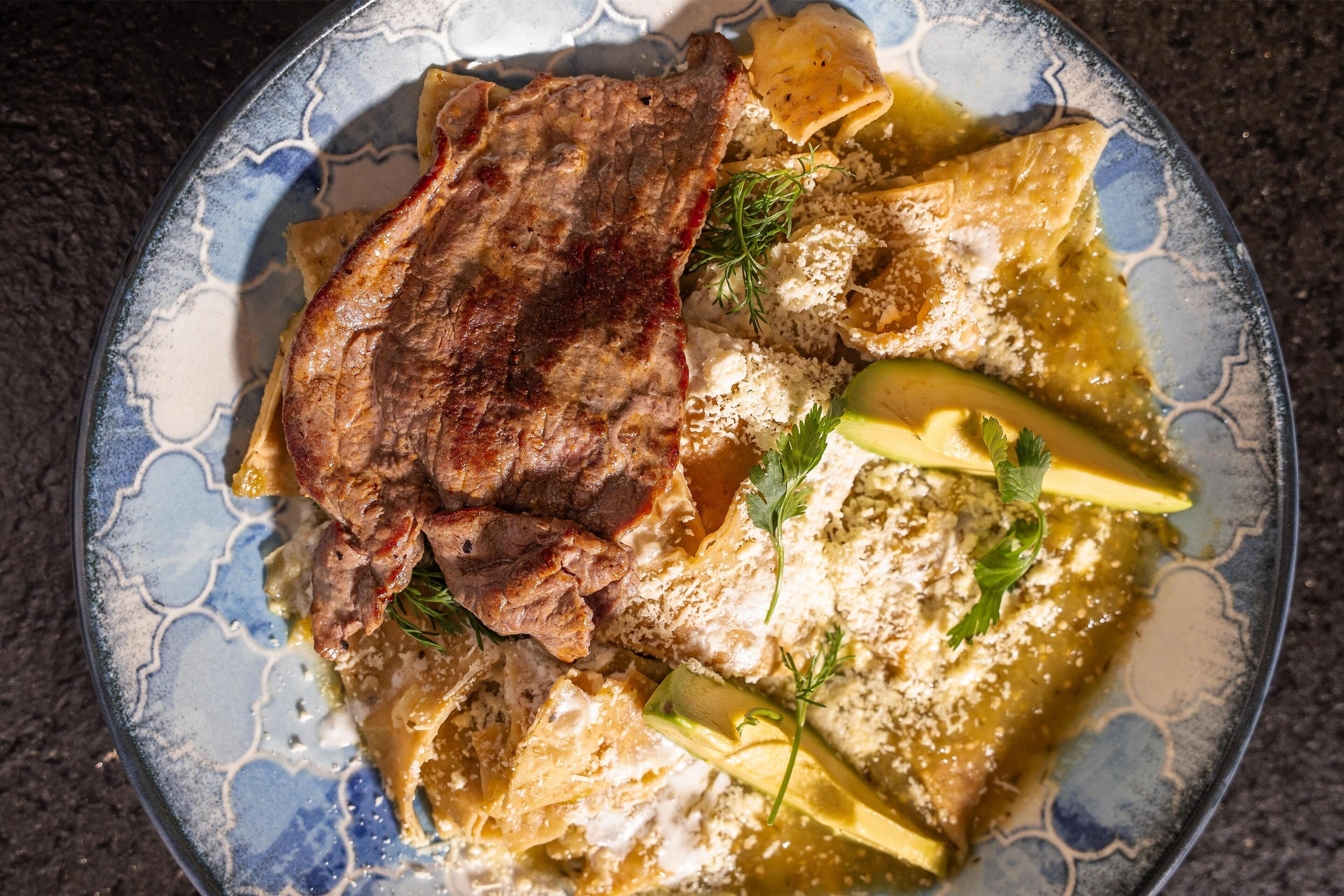 Une assiette de nourriture comprenant de la viande, du fromage et des légumes.