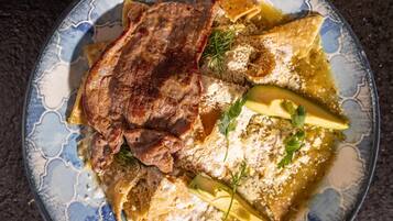 A plate of food with meat, cheese, and vegetables.