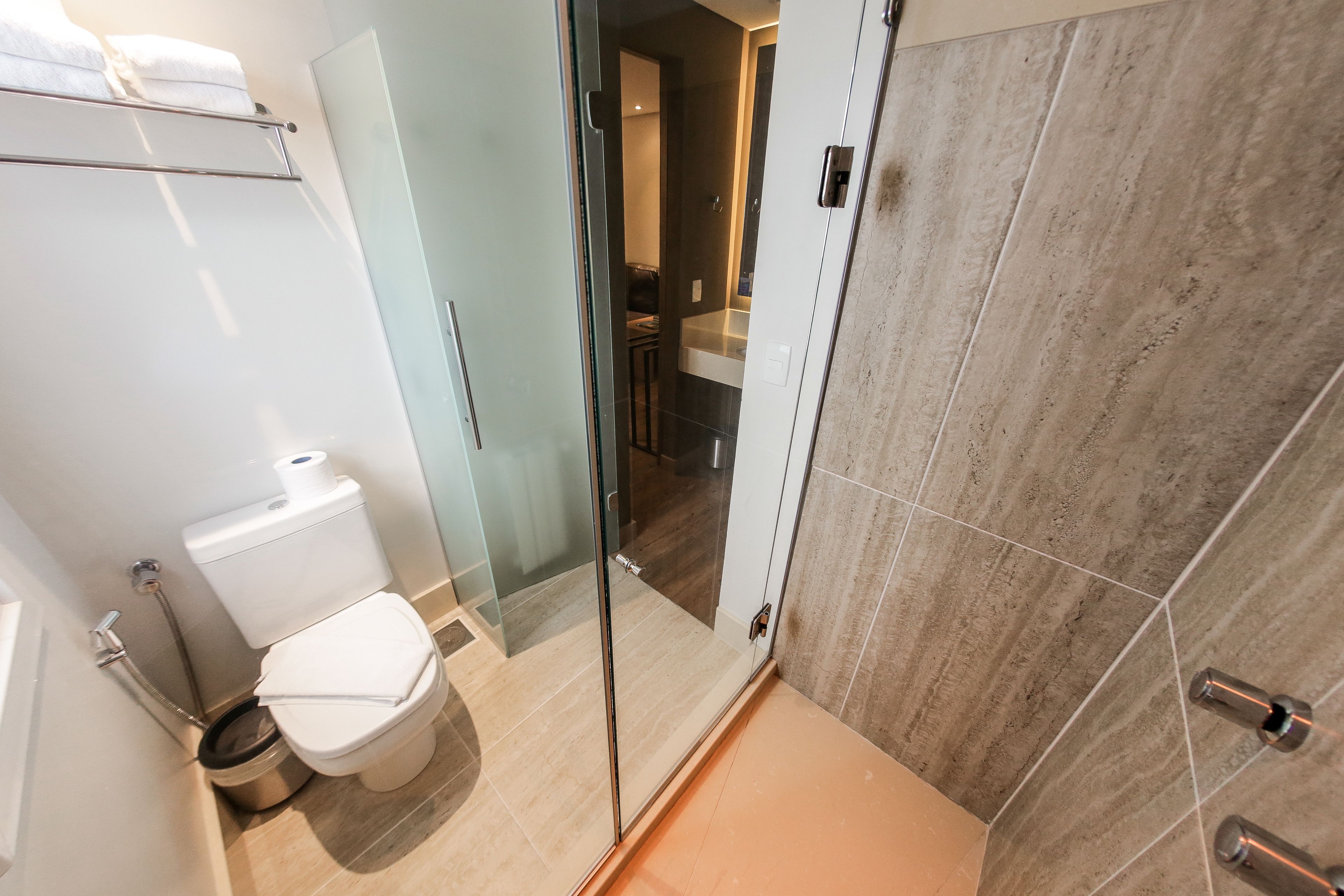 Un baño moderno con cabina de ducha de vidrio, inodoro y lavabo.
