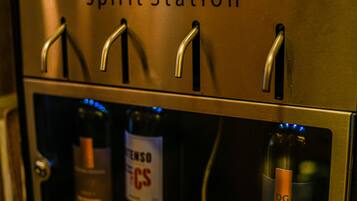 Una estación de dispensación de vino con cuatro grifos y dos botellas.